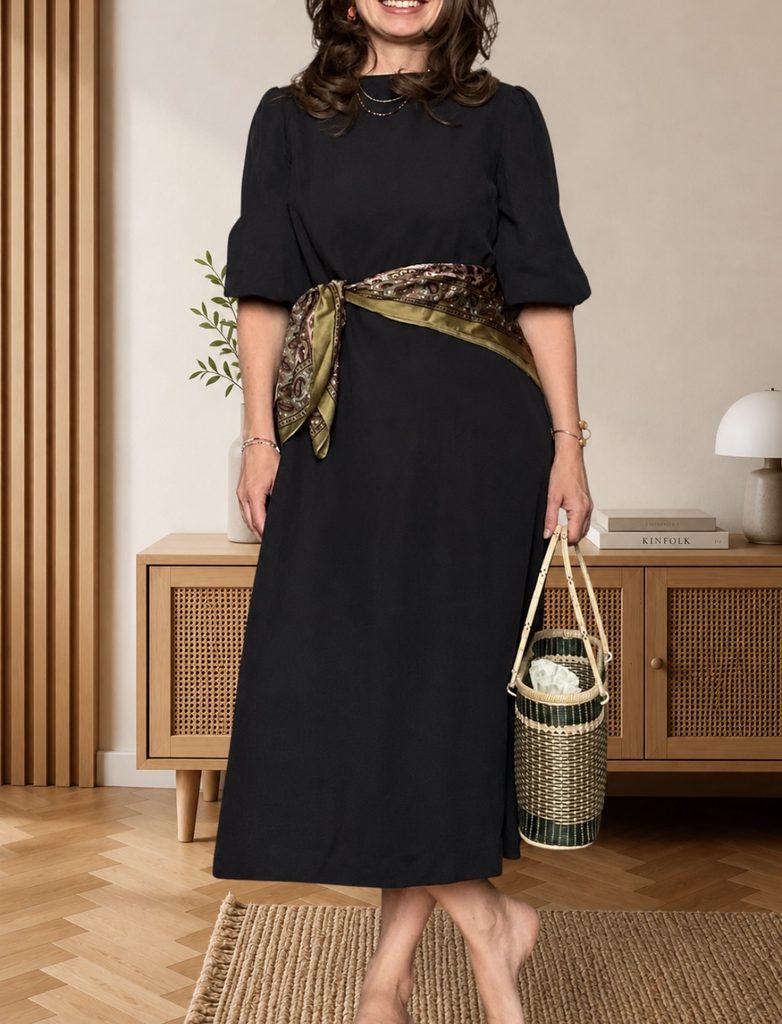 black midi dress with puff sleeves and a silk scarf tied as a belt at the waist, woven basket bag