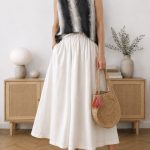 petite note no. 5 — the two lines that matter a petite woman in a white linen maxi skirt with a high waist and floor-length hem, worn with a sleeveless top and a straw bag