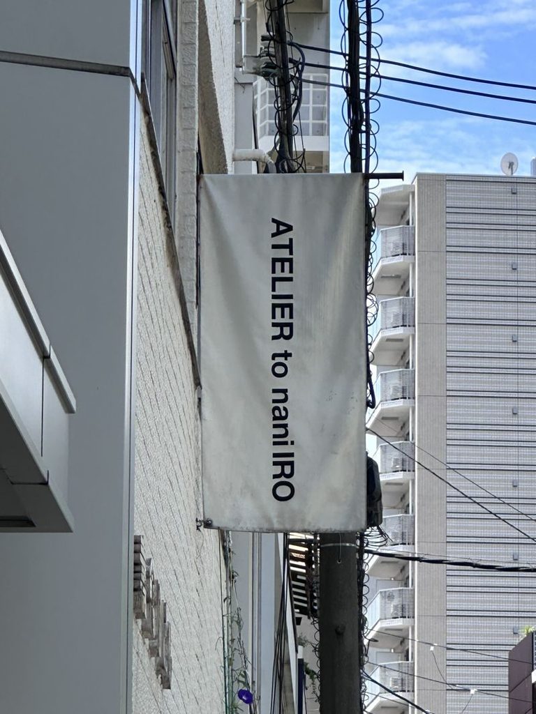 Inside Naomi Ito's nani IRO atelier in Osaka, a rail of finished garments by the window